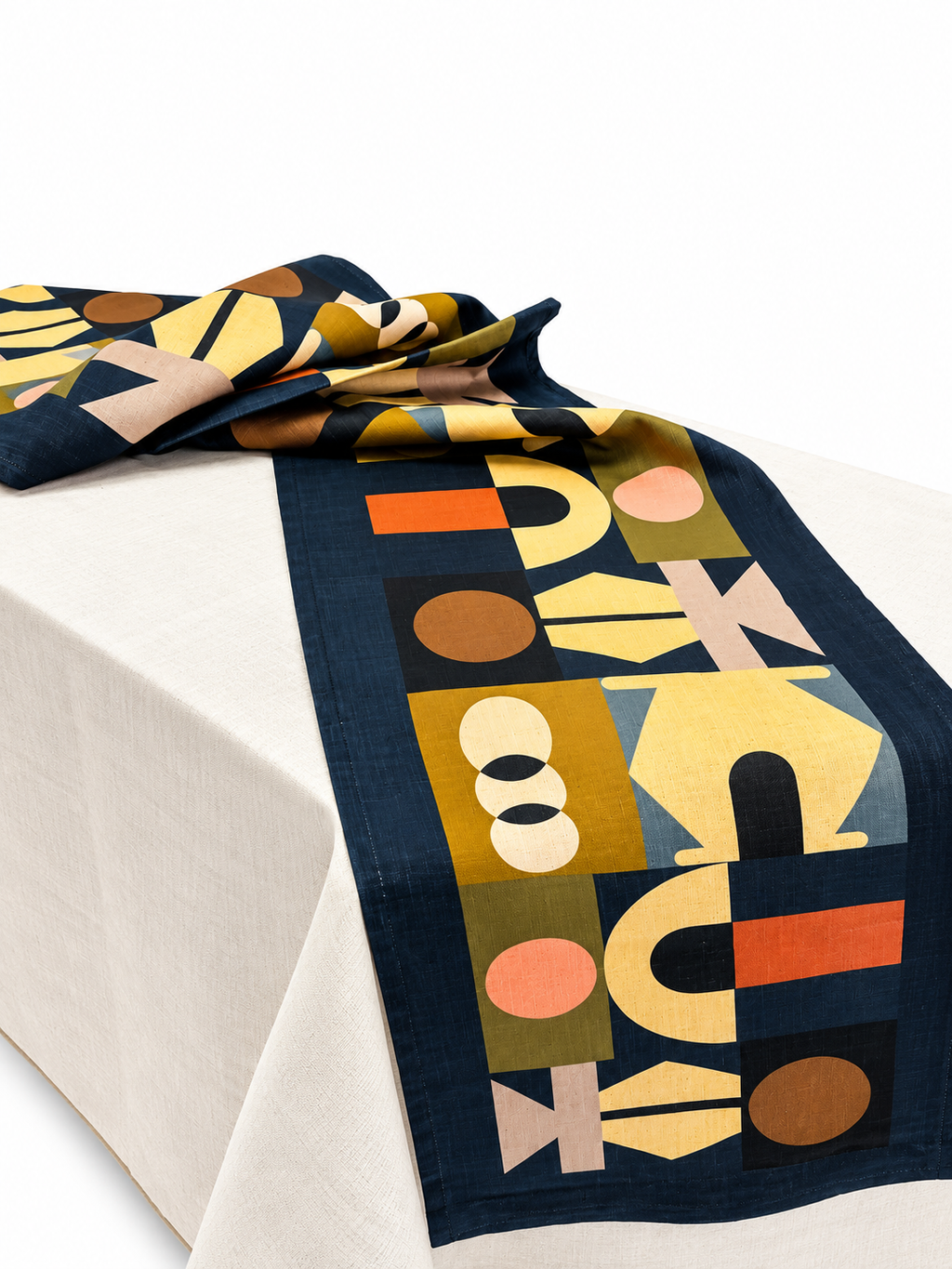 A navy blue Lulasclan table runner with a mid-century modern geometric pattern in mustard yellow, terracotta orange, olive green, and beige, draped over a white tablecloth on a white background.