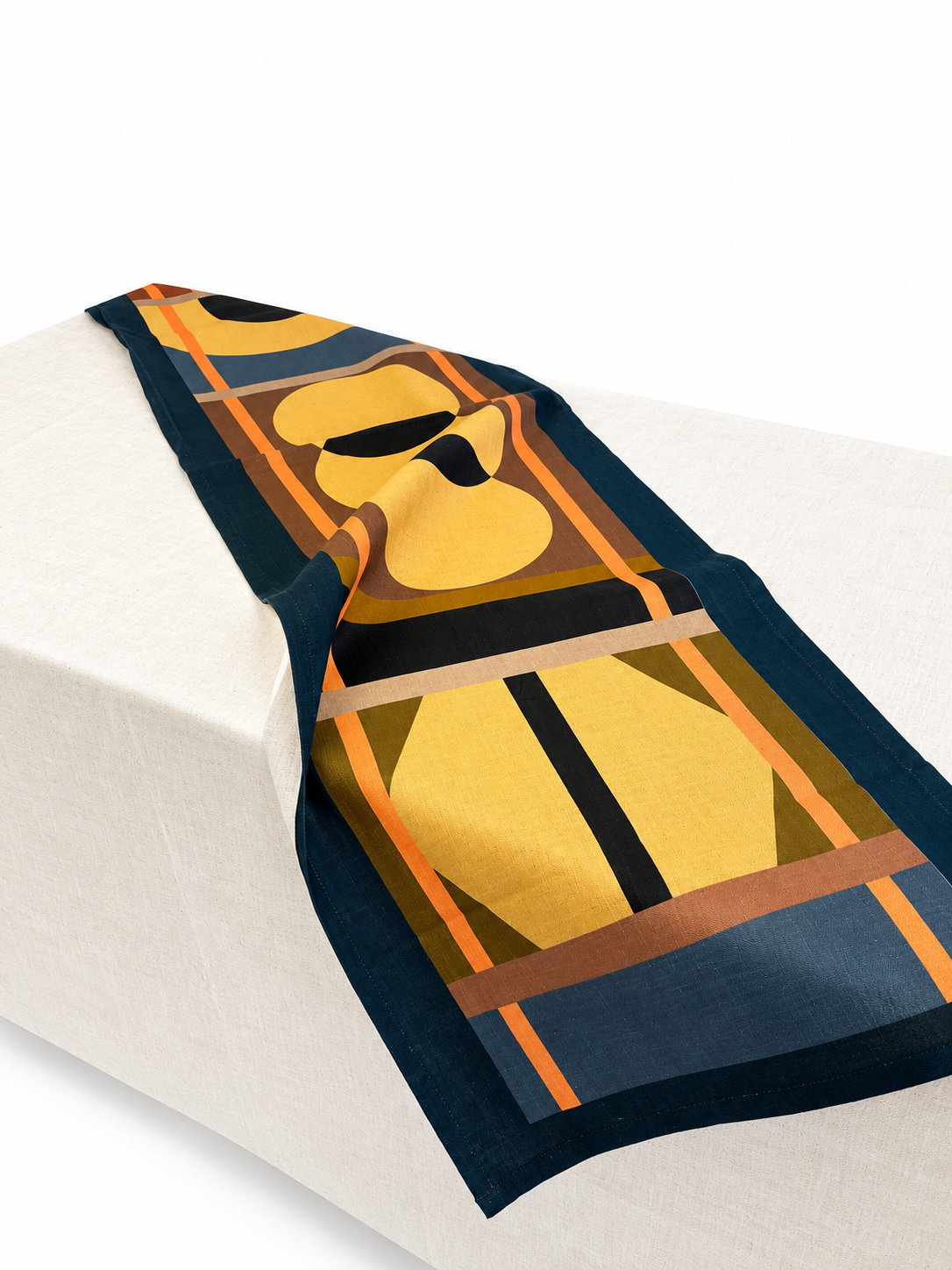 Lulasclan design table runner The Gathering in Navy Blue and Tangerine is placed on an off white linen draped table,  The design features geometric symbols in it's center in a dark beige set on a dark green, pale blue and browns make the design and is complimented by horizontal tangerine lines that frame the design borders. 
