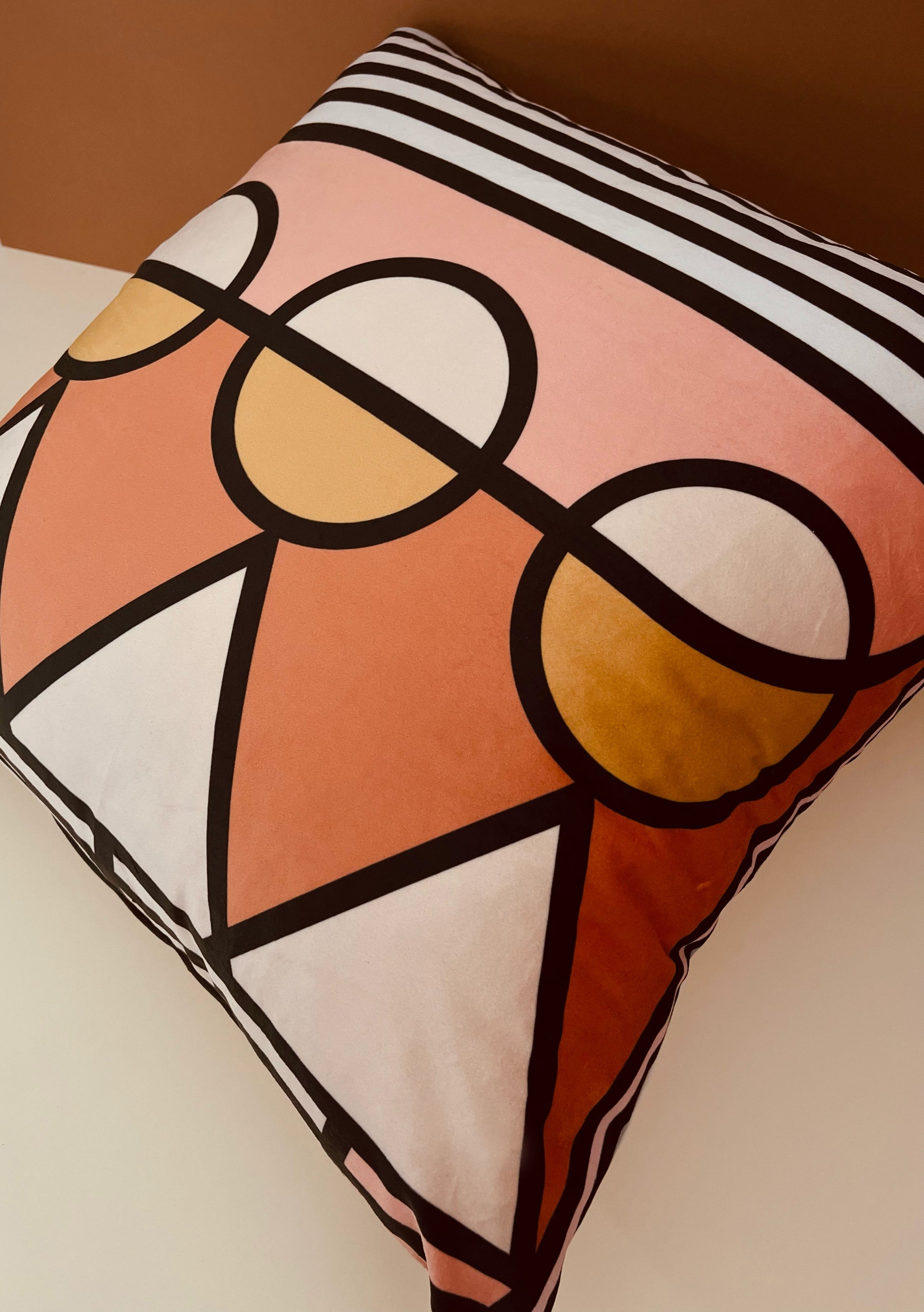 Orange, peach velvet 60cm x 60cm geometric decorative scatter cushion with circle and triangle pattern and plain matching background for bedroom and living room.